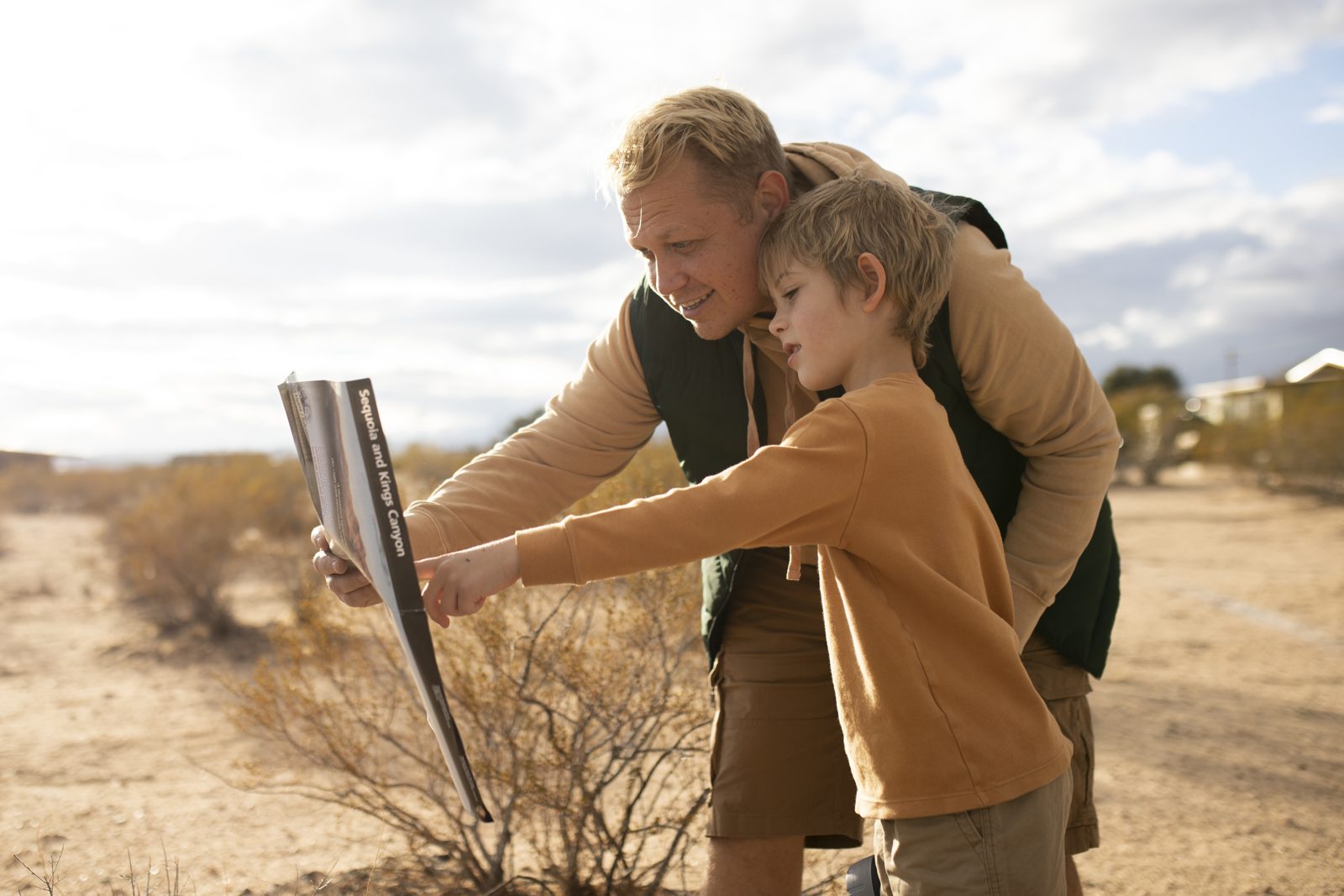 A father and child reading an information sign on a trail